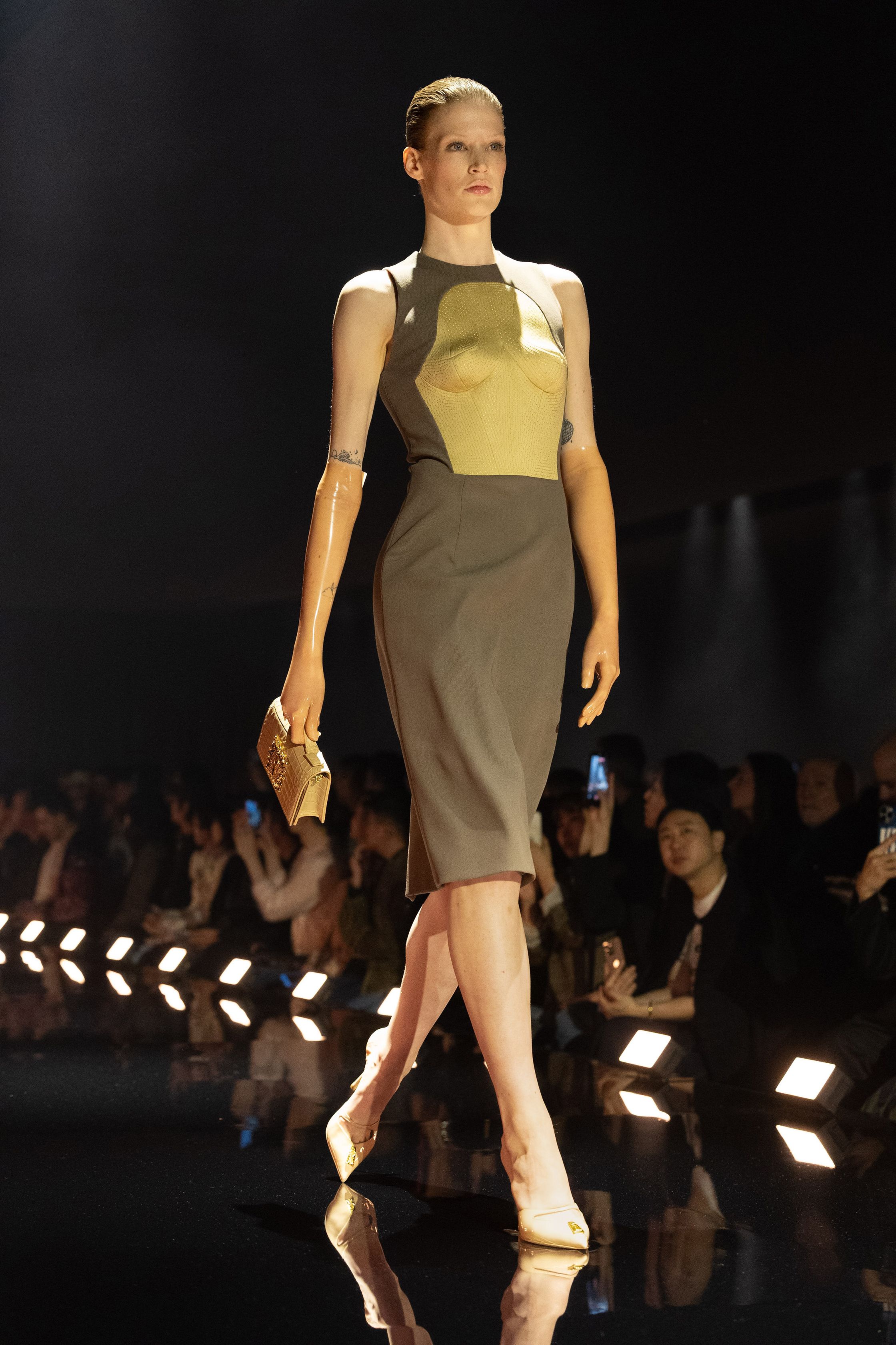 Schiaparelli 2026秋冬系列延续品牌标志性的超现实主义美学，在金色灯光的T台上呈现极具雕塑感的廓形。沙金色与黑金色成为主调，褶皱礼服、雕塑式西装与高腰裙装强化身体线条。经典的金属装饰、夸张肩线以及精致刺绣细节构成强烈视觉符号，使整场秀既华丽又充满戏剧张力。设计师通过结构与面料的张力对比，让高级定制的艺术精神融入现代女性衣橱-顽石频道趋势研究